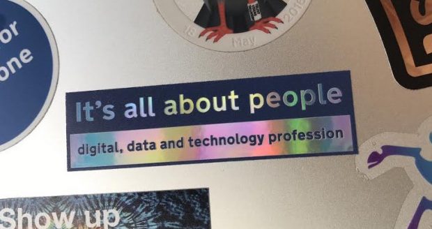 Laptop with sticker attached that reads 'It's all about people - digital, data and technology profession'. The photo is credited to Photo courtesy of @Here_comes_Abs on Twitter.