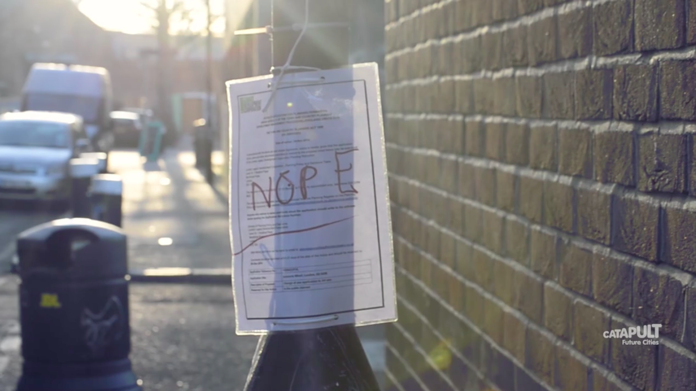 Planning notice on a lamppost with the word "NOPE" written across it.