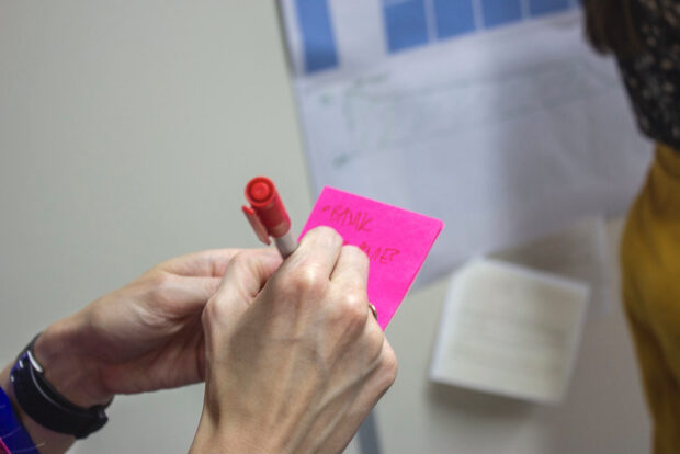 User writes on post-it during user research session