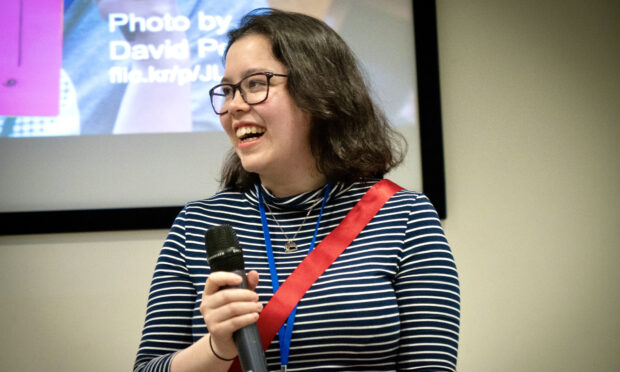 Coco Chan, Senior Product Manager, stands on stage holding a microphone