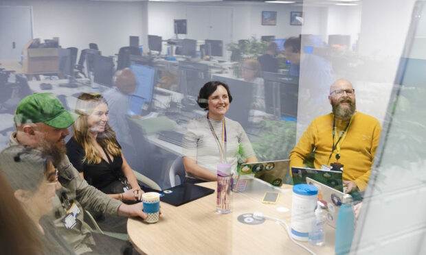 A group of colleagues sitting around a table having a meeting