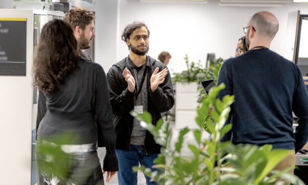 Four colleagues standing in a circle together and talking