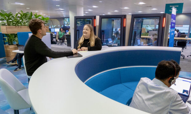 Two colleagues standing together in the office and talking