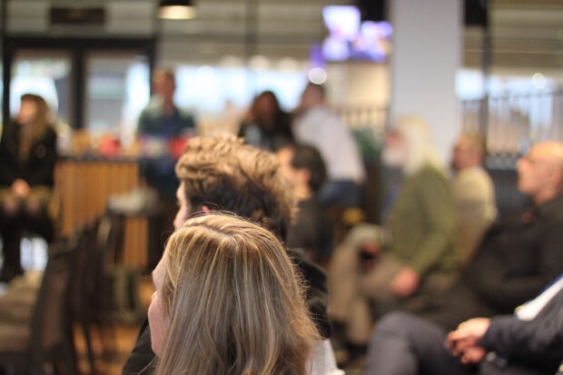 A room with people sitting down and listening to a talk
