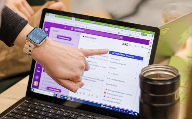 a person's hand pointing at a laptop screen, showing an online tool