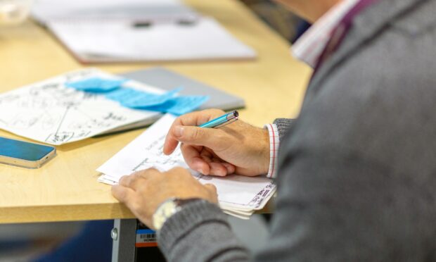 a person's hands writing on a piece of paper