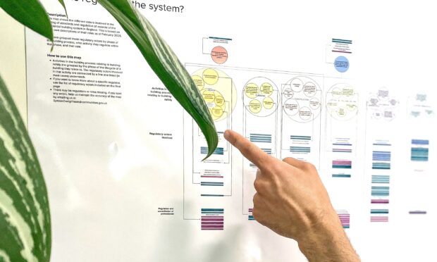 Someone pointing at some of the data on a system design map