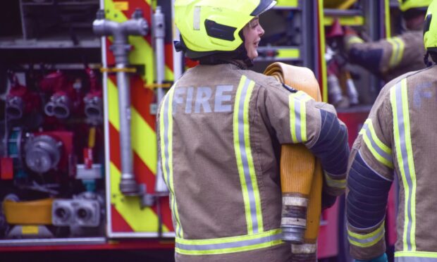 A firefighter with a fire engine in the background