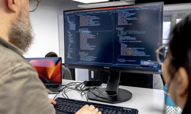 two colleagues working on code together