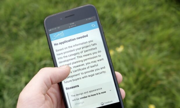 Mobile phone in a person's hand displaying the PlanX interface